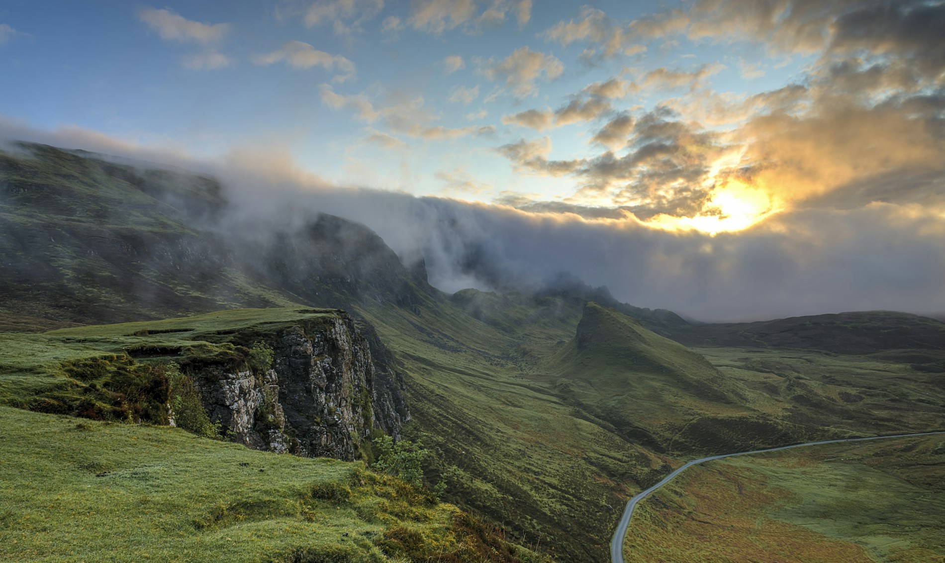 Sunlight and mist falling across green mountain ridges